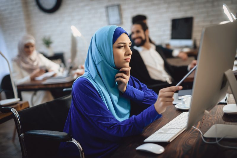 Middle Eastern young lady looking at computer screen